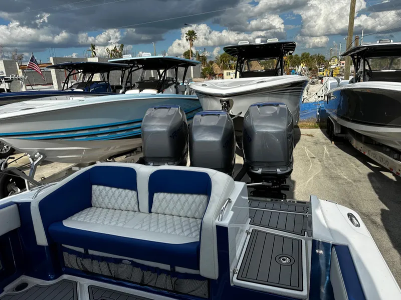 Slide: The Image of 2017 Nor-Tech 390 Center Console with triple outboard engines, docked under cloudy skies. - 20