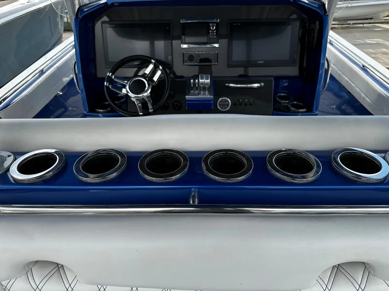 Slide: The Image of 2017 Nor-Tech 390 Center Console dashboard with steering wheel and multiple cup holders. - 25