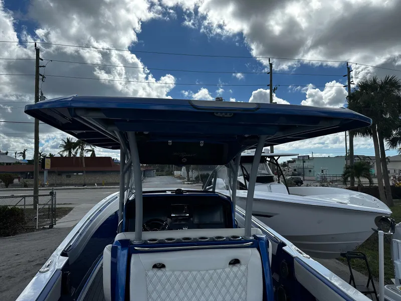 Slide: The Image of 2017 Nor-Tech 390 Center Console boat with blue canopy under cloudy sky. - 6