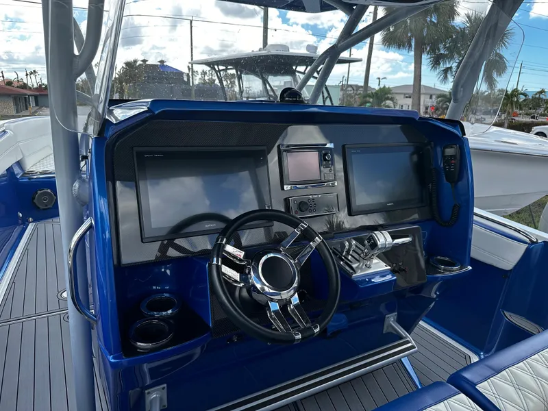Slide: The Image of 2017 Nor-Tech 390 Center Console boat dashboard with modern navigation equipment and steering wheel. - 9