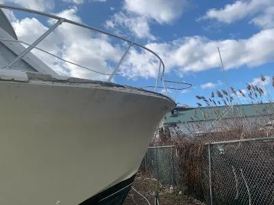Slide: The Image of 1975 Chris-Craft 30 Tournament FB boat docked near a fence under a partly cloudy sky. - 4