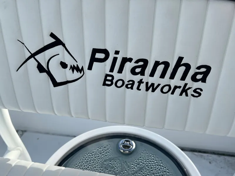 Slide: The Image of Piranha Boatworks logo on white boat seat, model B2200 CASADOR, 2023. - 17