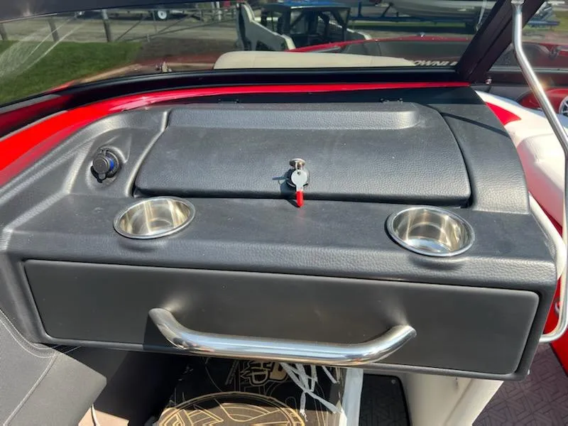 Slide: The Image of 2023 Crownline 240 SS boat dashboard with cup holders and storage compartment. - 2