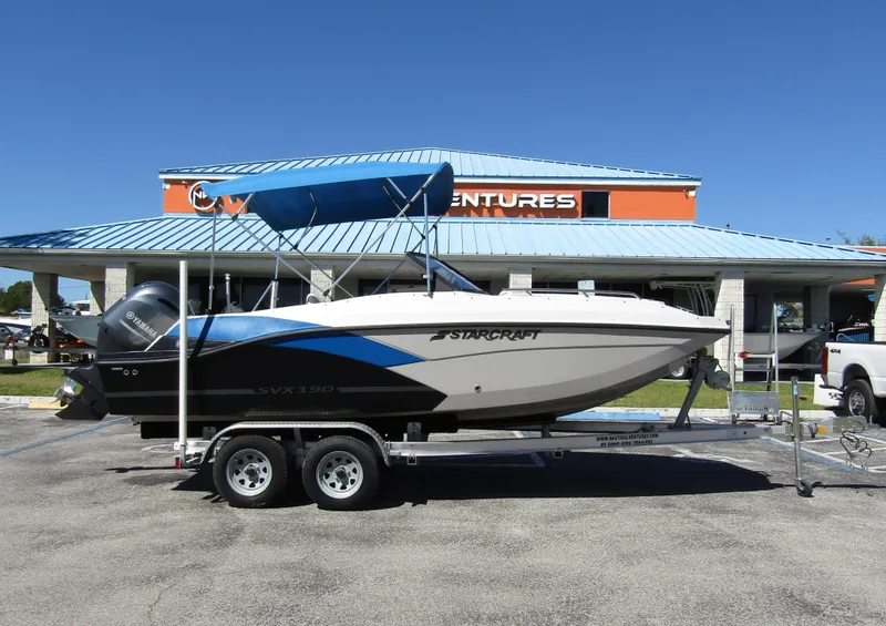 Slide: The Image of 2023 Starcraft SVX 190 OB boat on trailer, parked outside dealership. - 4
