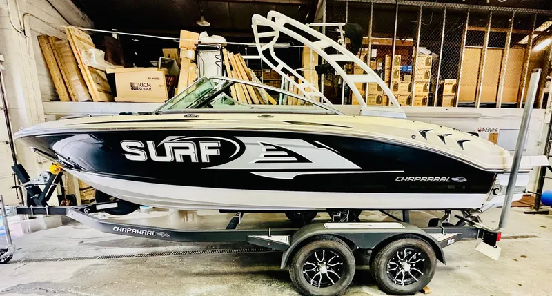 Slide: The Image of 2023 Chaparral 21 Surf boat in a garage, showcasing sleek design and modern features. - 1