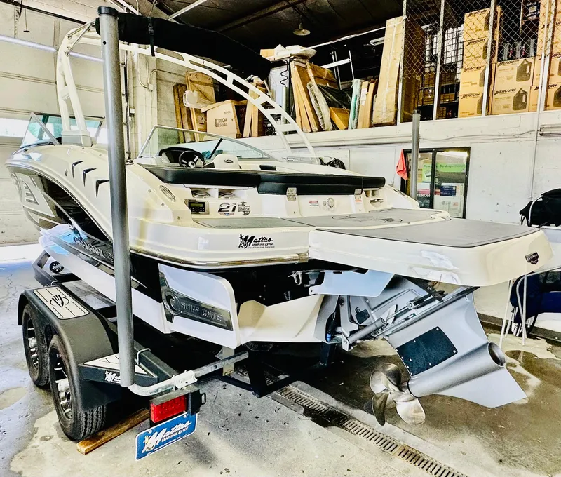 Slide: The Image of 2023 Chaparral 21 Surf boat interior with white seating and dashboard. - 13