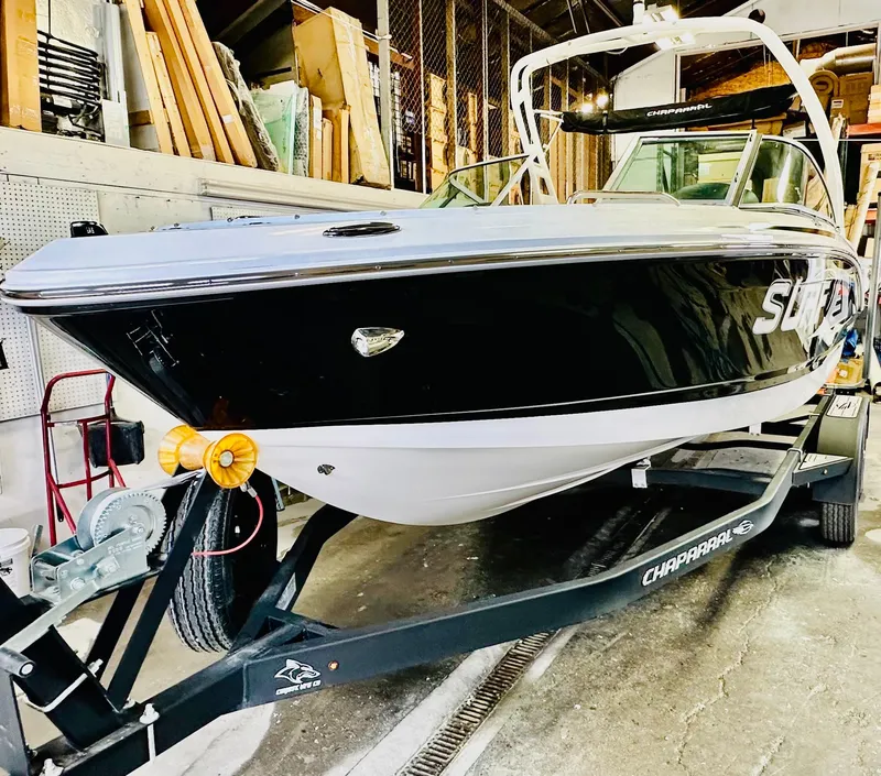 Slide: The Image of 2023 Chaparral 21 Surf boat on trailer in storage facility. - 2