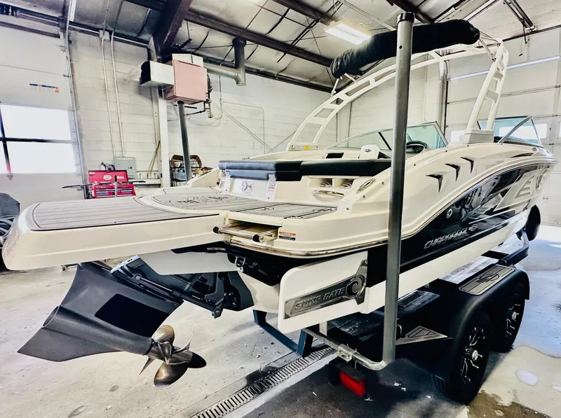 Slide: The Image of 2023 Chaparral 21 Surf boat in a garage, showcasing sleek design and powerful engine. - 4