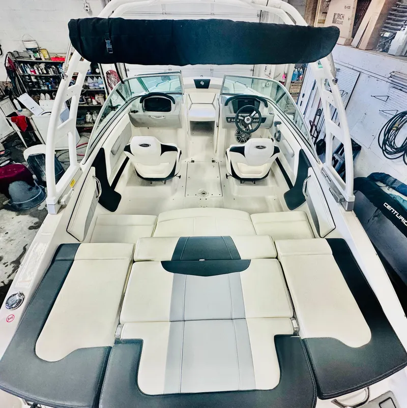Slide: The Image of 2023 Chaparral 21 Surf boat interior with seating and steering wheel in a workshop. - 7