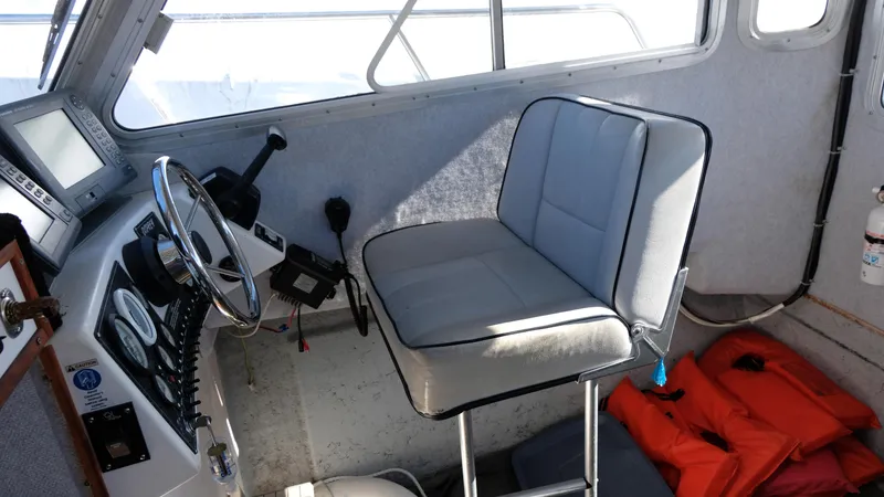 Slide: The Image of Interior of a 1999 Osprey 24 boat showing helm, seat, and life jackets. - 10