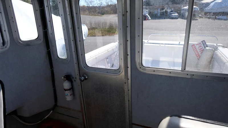 Slide: The Image of Interior view of a 1999 Osprey 24 boat, featuring windows and a door. - 14