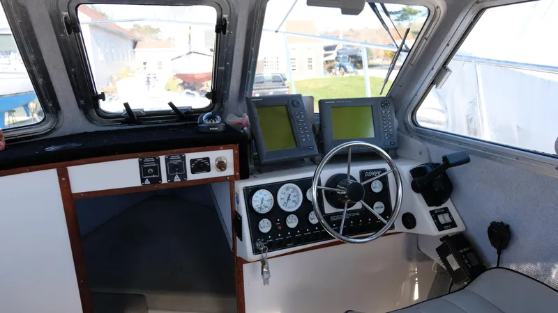 Slide: The Image of Interior of a 1999 Osprey 24 boat cockpit with navigation instruments and steering wheel. - 2