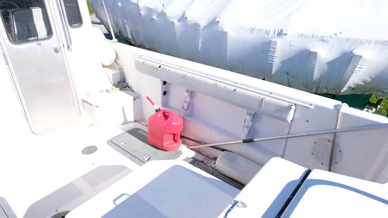 Slide: The Image of 1999 Osprey 24 boat deck with red fuel can and covered equipment. - 7