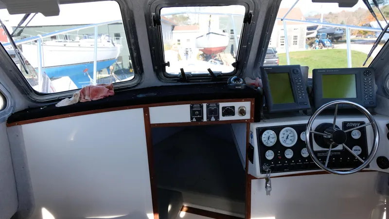 Slide: The Image of 1999 Osprey 24 boat cockpit with steering wheel, gauges, and navigation screens. - 8