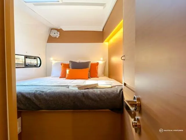 Slide: The Image of 2024 Excess 11 yacht cabin with cozy bed, modern lighting, and porthole window. - 15