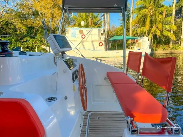 Slide: The Image of 2024 Excess 11 sailboat cockpit with red seating, steering wheel, and navigation equipment. - 40