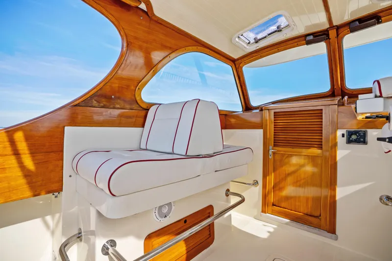 Slide: The Image of Interior of 1996 Hinckley 36 Picnic Boat Classic with wooden accents and cushioned seating. - 14