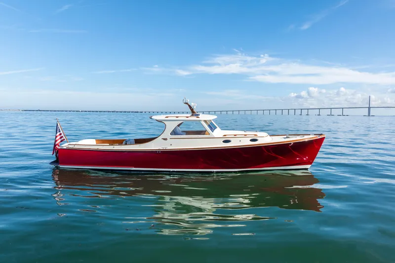 The Image of 1996 Hinckley 36 Picnic Boat Classic on calm water with bridge in background. - 0