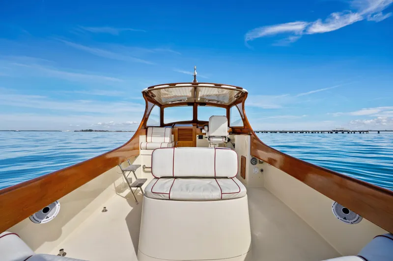 Slide: The Image of Hinckley 36 Picnic Boat Classic 1996 on calm water, featuring elegant wood and white seating. - 10