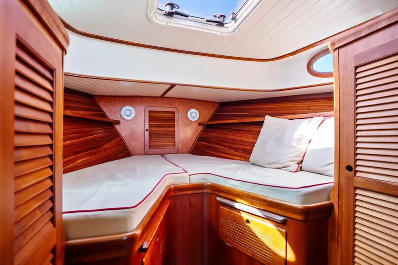 Slide: The Image of Cozy cabin interior of 1996 Hinckley 36 Picnic Boat Classic with wooden finish and cushions. - 17