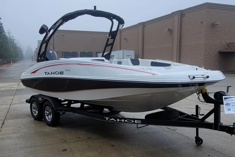 Slide: The Image of 2023 Tahoe 1950 boat on trailer in industrial area. - 2