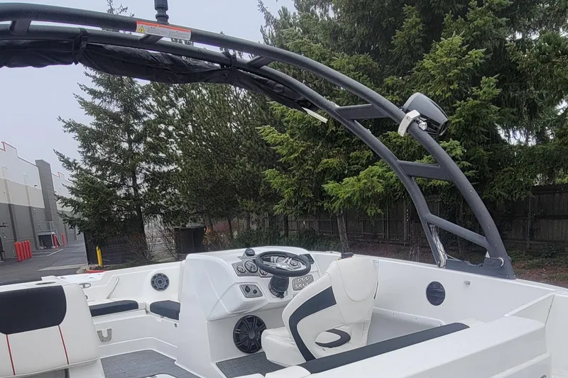 Slide: The Image of 2023 Tahoe 1950 boat interior with steering wheel and seating, surrounded by trees. - 4