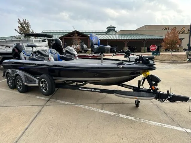 The Image of 2023 Ranger Z521R fishing boat on a trailer in a parking lot. - 1
