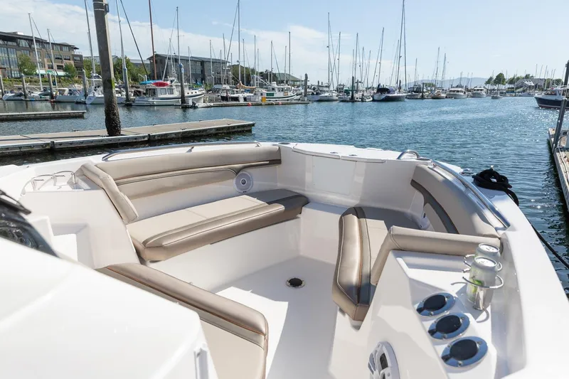 Slide: The Image of 2023 Solara S-250 CW boat interior at marina with seating and cup holders. - 12