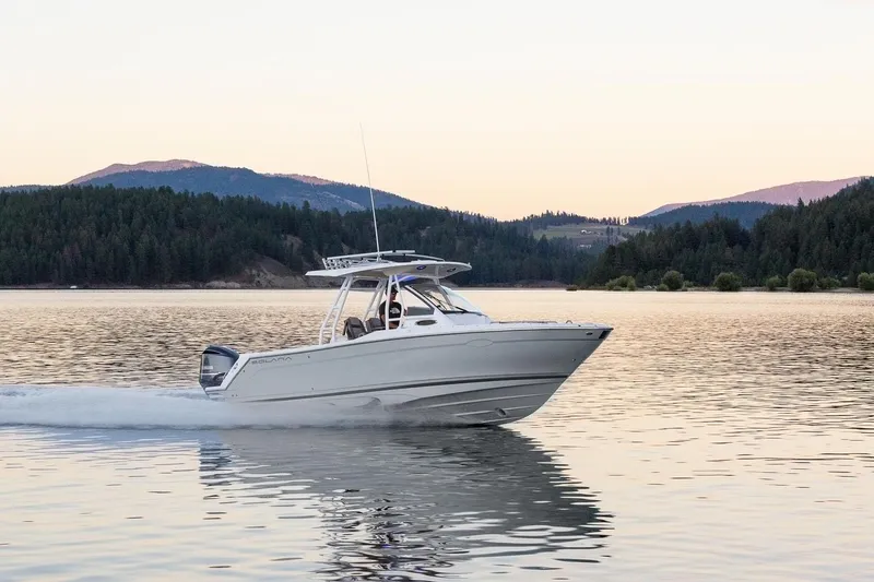 Slide: The Image of 2023 Solara S-250 CW boat cruising on a serene lake at sunset. - 34