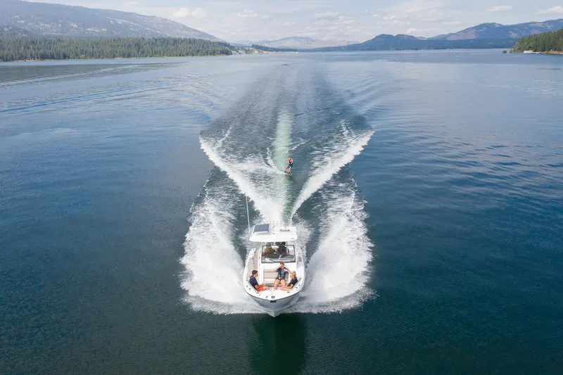 Slide: The Image of 2023 Solara S-250 CW boat towing a wakeboarder on a scenic lake. - 35