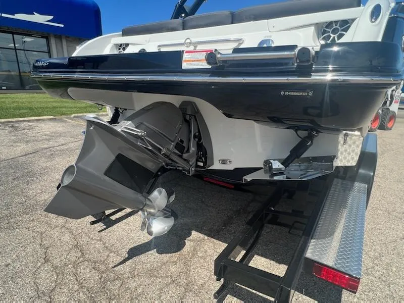 Slide: The Image of 2023 Crownline 240 SS SURF boat on a trailer, rear view showing propeller and outdrive. - 8
