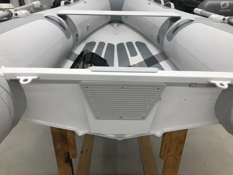 Slide: The Image of 2023 Zodiac Cadet 300 RIB ALU PVC boat, white, displayed on wooden stands. - 8