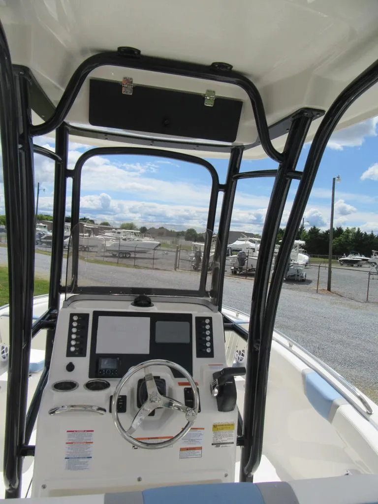 Slide: The Image of 2023 Robalo R222 Center Console boat dashboard with steering wheel and navigation screens. - 11