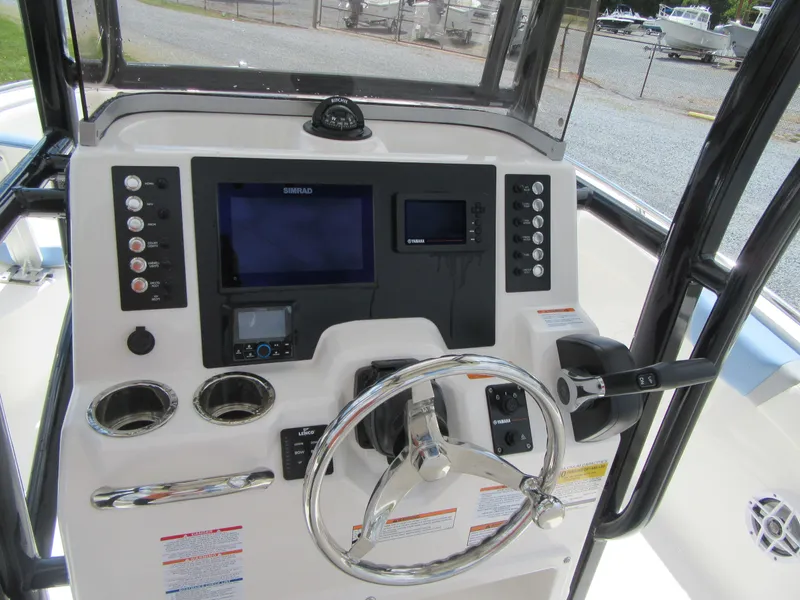 Slide: The Image of 2023 Robalo R222 Center Console boat dashboard with steering wheel and navigation controls. - 12