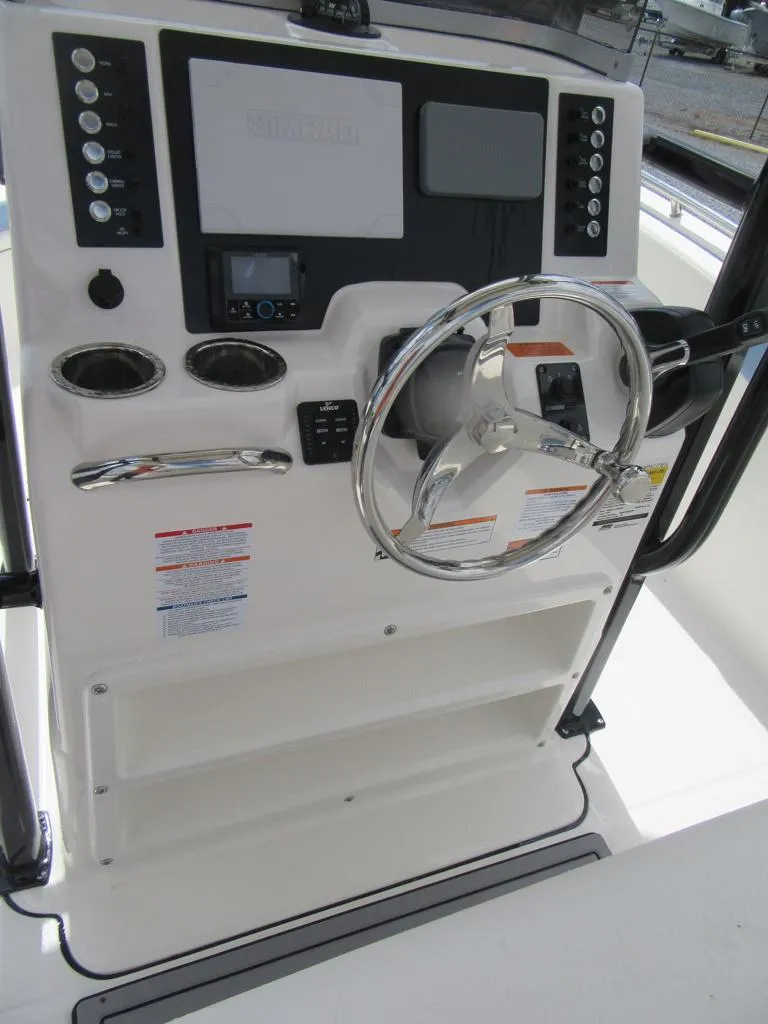 Slide: The Image of 2023 Robalo R222 Center Console boat helm with steering wheel and control panel. - 13