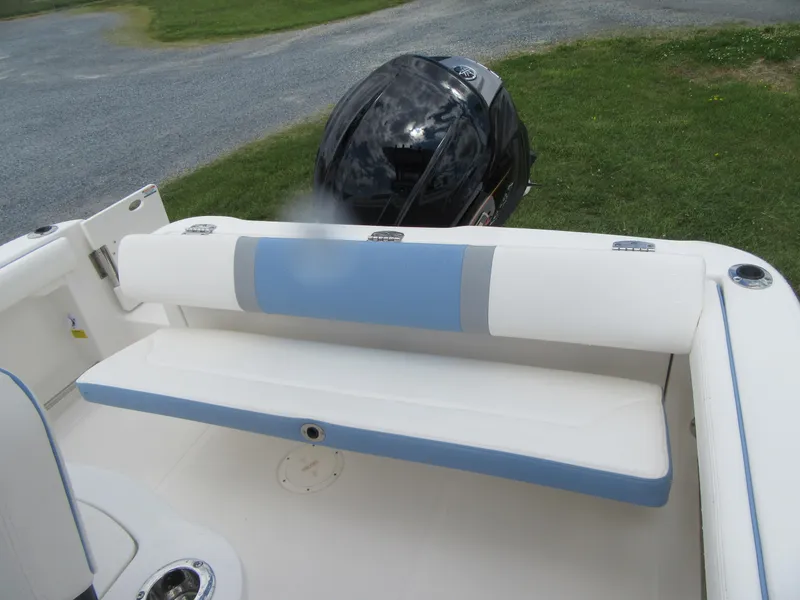 Slide: The Image of 2023 Robalo R222 Center Console boat with cushioned seating and outboard motor. - 19