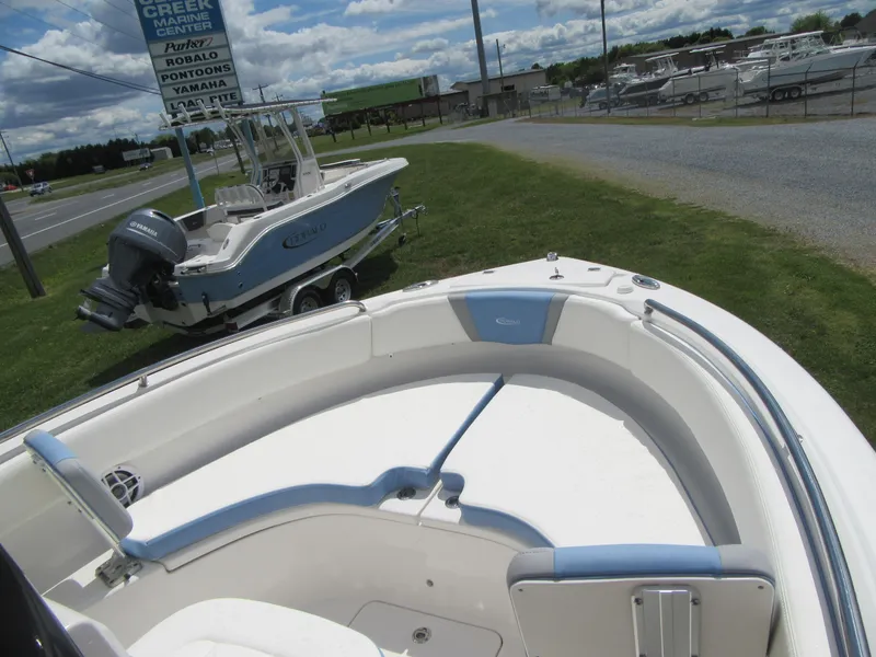Slide: The Image of 2023 Robalo R222 Center Console boat on display at a marina with another boat in the background. - 24