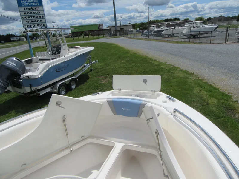 Slide: The Image of 2023 Robalo R222 Center Console boat on display at a marina. - 5