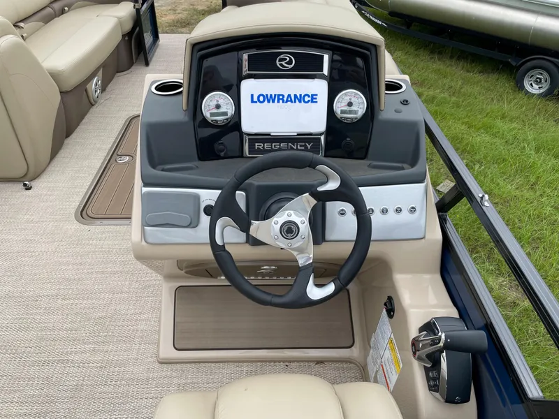 Slide: The Image of 2023 Regency 250 DL3 boat dashboard with steering wheel and Lowrance display. - 3