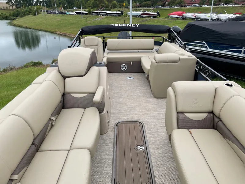 Slide: The Image of 2023 Regency 250 DL3 pontoon boat with luxurious beige seating and spacious deck. - 6