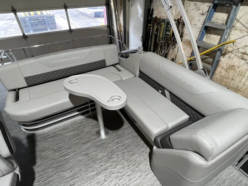 Slide: The Image of 2023 Bennington 22SXSB boat interior with gray seating and a central table. - 13