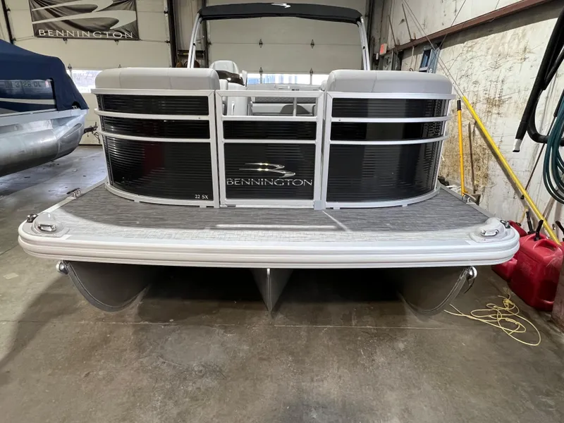 Slide: The Image of 2023 Bennington 22SXSB pontoon boat in a garage setting. - 6