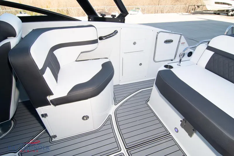 Slide: The Image of 2023 Monterey M6 boat interior with white and black seating and gray flooring. - 24