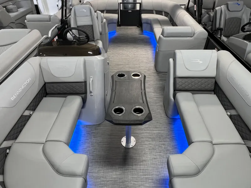 Slide: The Image of 2023 Bennington 22SXSRC pontoon boat interior with gray seating and blue LED lighting. - 14