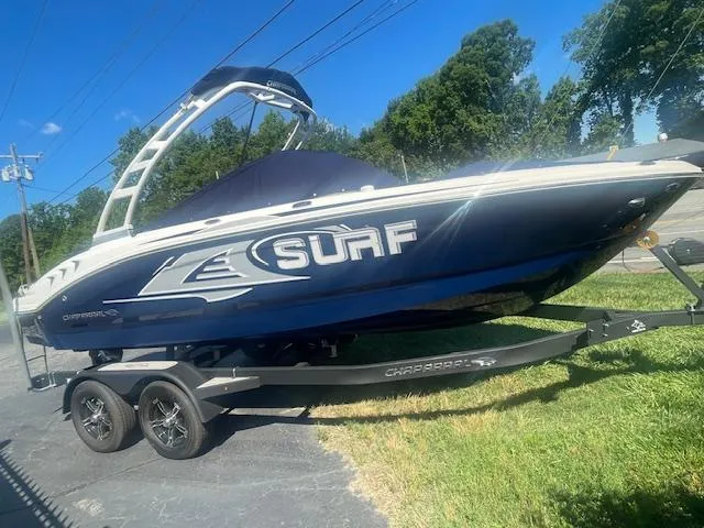 The Image of 2023 Chaparral 21 Surf boat on trailer, parked on driveway, sunny day. - 0
