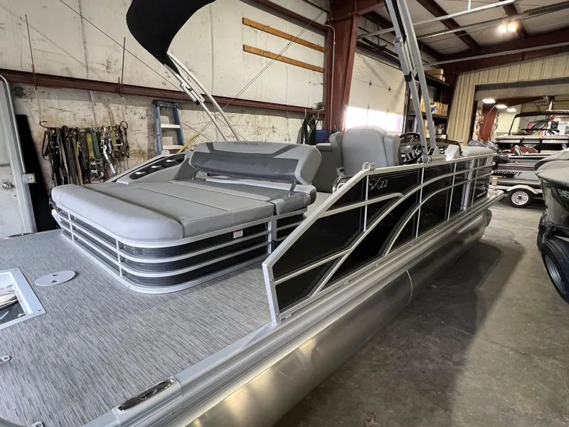 Slide: The Image of 2023 Bennington 22SXSB pontoon boat in a warehouse, featuring sleek design and comfortable seating. - 11
