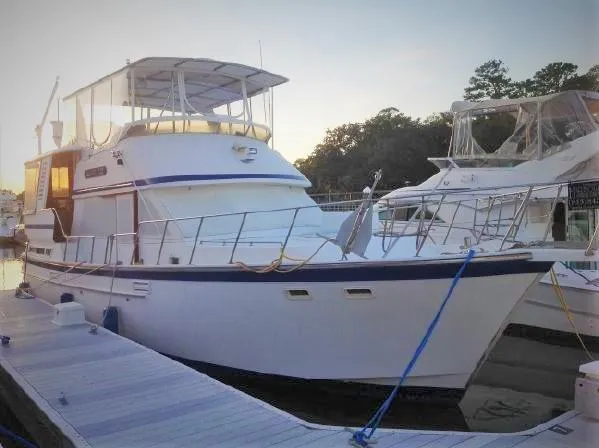 Slide: The Image of 1987 Jefferson 42 Sundeck Motor Yacht docked at marina during sunset. - 1
