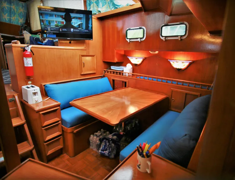 Slide: The Image of 1987 Jefferson 42 Sundeck Motor Yacht interior with dining area and TV. - 17
