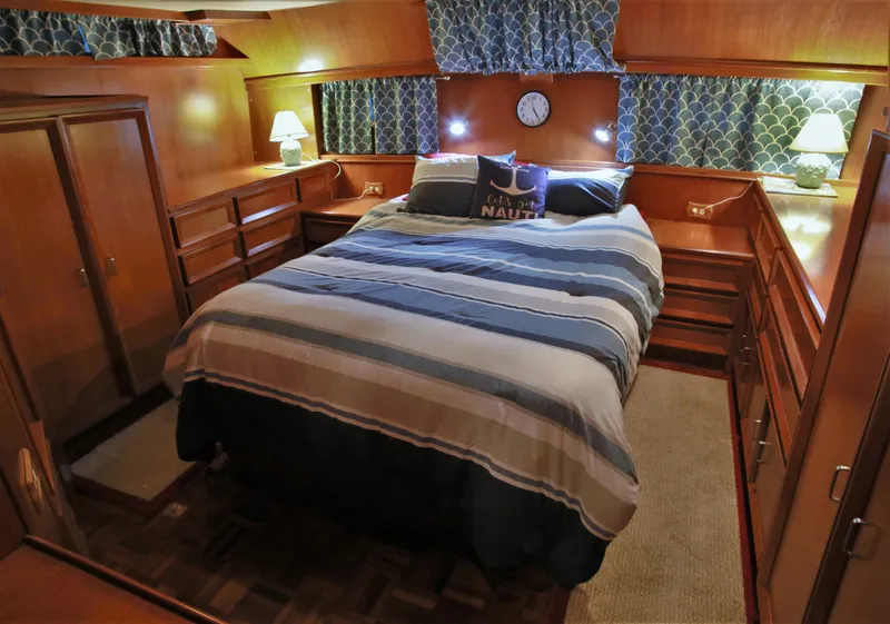 Slide: The Image of 1987 Jefferson 42 Sundeck Motor Yacht bedroom with cozy bed, wooden cabinetry, and nautical decor. - 35