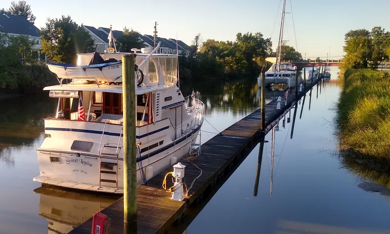 Slide: The Image of 1987 Jefferson 42 Sundeck Motor Yacht docked on a calm river. - 43